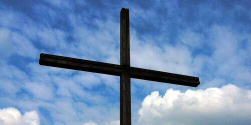 Ein Kreuz aus Holz im Hintergrund der Himmel
