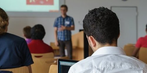 Ein Mann sitzt mit einem Laptop bei einem Seminar