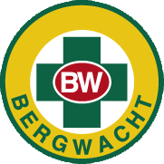 innen: grünes Kreuz mit den Buchstaben BW in der Mitte, außen: großer Kreis mit Aufschrift BERGWACHT 