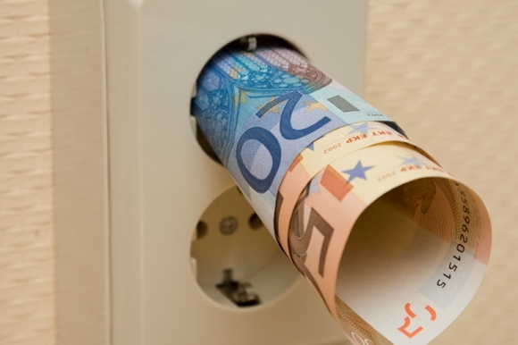 Zwei Euroscheine stecken zusammen gerollt in einer Steckdose