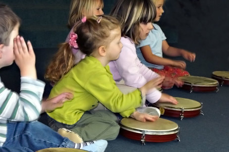 Kinder spielen mit Trommeln.