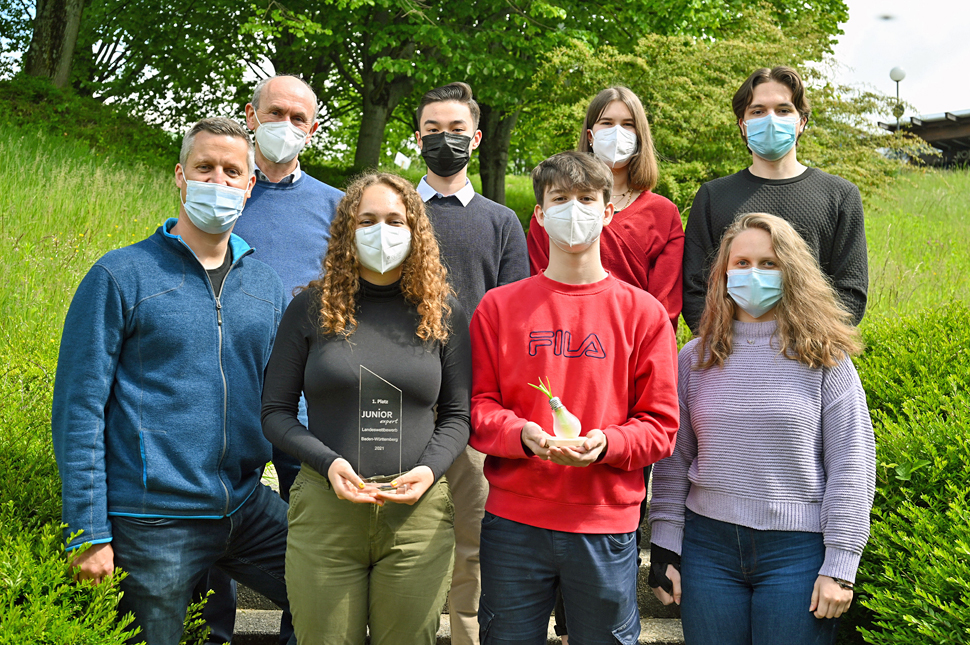 Gruppenfoto mit Pokal: Vordere Reihe von rechts Julia Schulz (Leitung Finanzen), Robin Schulz (Vorstandsvorsitzender), Amy Exner (Vorstandsvorsitzende), Daniel Willemsen (Schulpate); hintere Reihe von rechts nach links mit Kenan Seckanovic (Leitung Produktion), Larissa Kiefer (Leitung Marketing), Frederik Sliwa (Homepage) und Matthias Schmauder (Schulleiter).