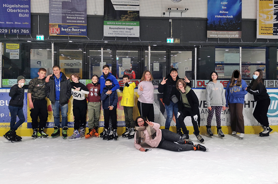 Gruppenfoto der Teilnehmer auf der Eislaufbahn