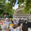 Eröffnung des Welterbefests: Vor der Kurmuschel im Kurgarten sitzen Menschen in Stuhlreihen. OB Mergen steht auf der Bühne. 