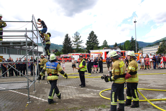Feuerwehrleute klettern ein Gerüst hoch. 