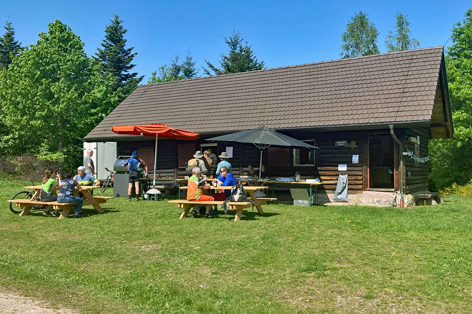 Gäste sitzen an Tischen vor der Jahnhütte