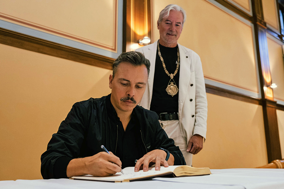 Tino Piontek verewigt sich im Goldenen Buch. Hinter ihm steht Oberbürgermeister Dietmar Späth.