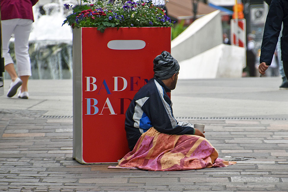 Bettler sitzt in der Fußgängerzone