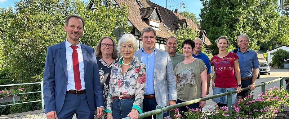 Gruppenbild vor blühenden Blumenkästen auf einer Brücke.