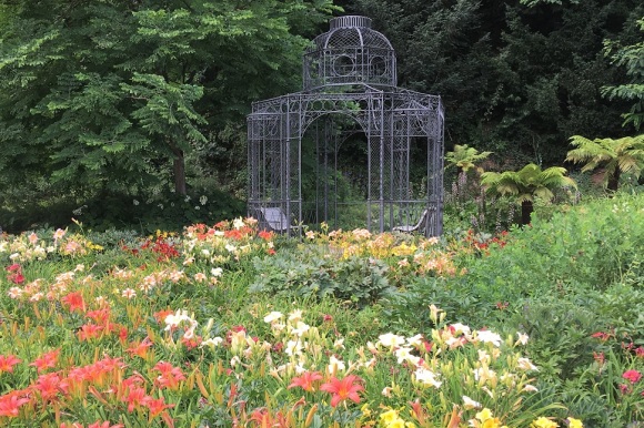 Ein Pavillon umgeben von blühenden Beeten.