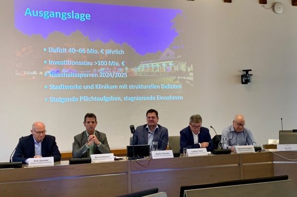 Fünf Personen sitzen vor dem Gemeinderat. 