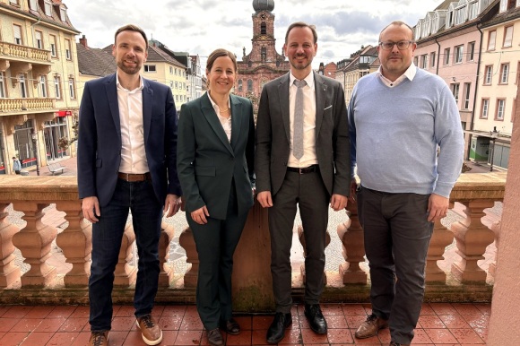 4 Menschen stehen in einer Reihe auf dem Rastatter Rathausbalkon nebeneinander.