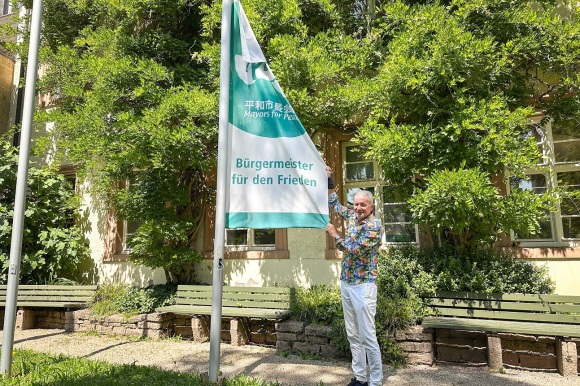 OB Dietmar Späth hisst die Flagge der Bürgermeister für den Frieden im Innenhof des Rathauses.