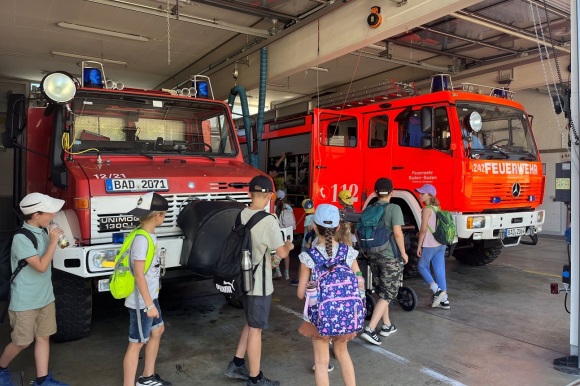 Mehrere Kinder stehen vor einem Feuerwehrauto.