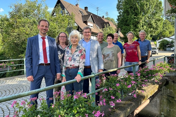 Gruppenbild vor blühenden Blumenkästen auf einer Brücke.