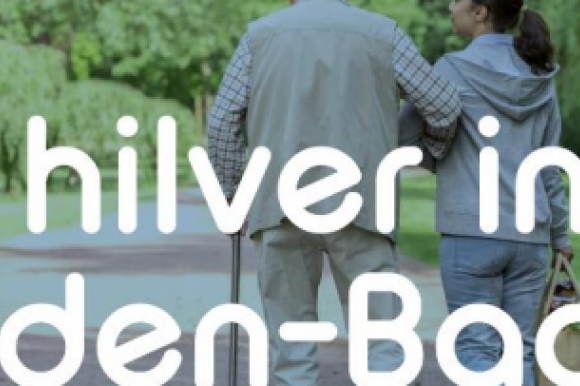 Zwei Senioren laufen im Grünen. Darüber steht der Schriftzug "Hilver in Baden-Baden".