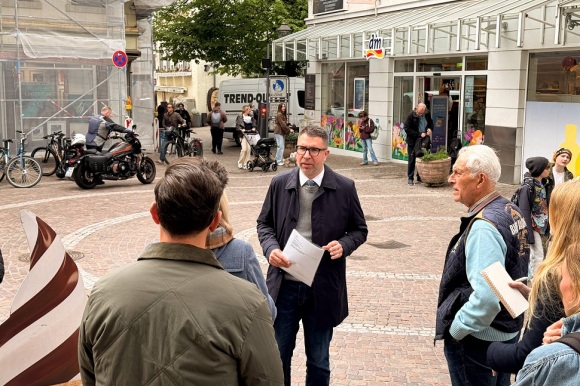 Bürgermeister Dr. Krammerbauer steht vor einer Gruppe Menschen auf dem Sonnenplatz.