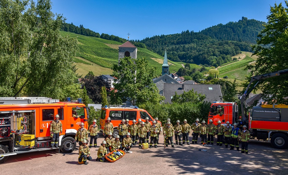 Gruppenbild der Mitglieder der Feuerwehr Neuweier mit ihren Einsatzfahrzeugen.