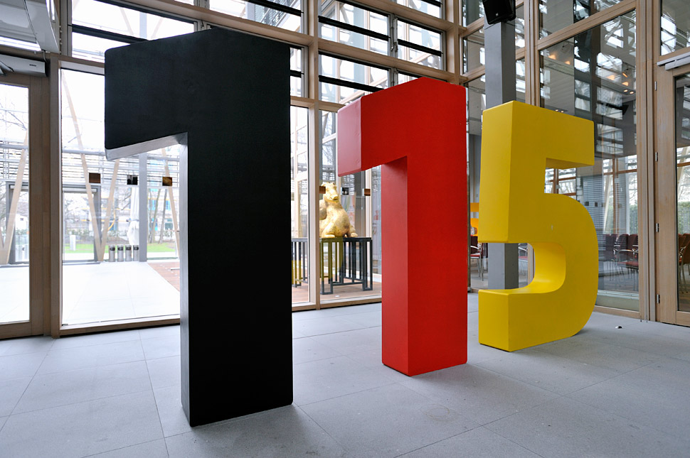 Riesige Zahlen: eine 1 in schwarz, eine 1 in rot und eine 5 in gelb.