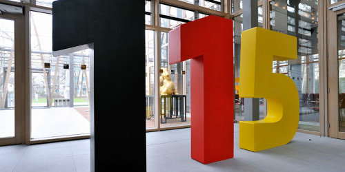 Riesige Zahlen: eine 1 in schwarz, eine 1 in rot und eine 5 in gelb.