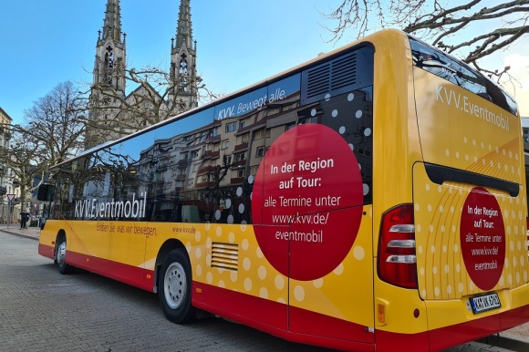 Ein gelber Bus steht an der Haltestelle am Augustaplatz.