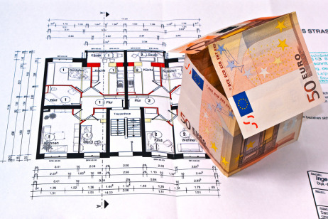 Bauplan, auf dem ein Haus aus 50-Euro Scheinen steht
