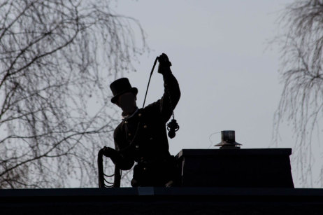 Schornsteinfeger auf einem Dach