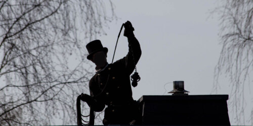 Schornsteinfeger auf einem Dach