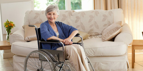 Ältere Dame im Rollstuhl in ihrer Wohnung