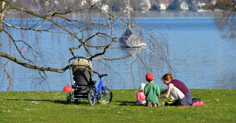 Eine Mutter picknickt mit ihren zwei Kindern auf einer Wiese