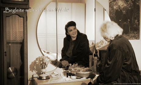 Eine ältere Frau sieht sich im Spiegelbild als junge Frau