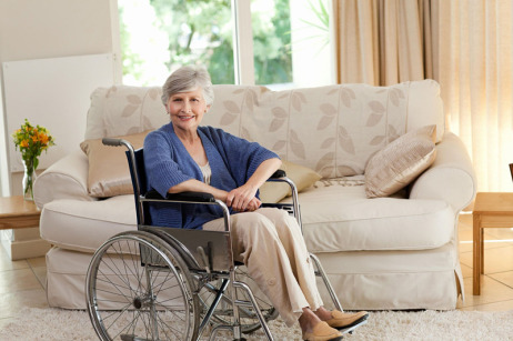Ältere Dame im Rollstuhl in ihrer Wohnung