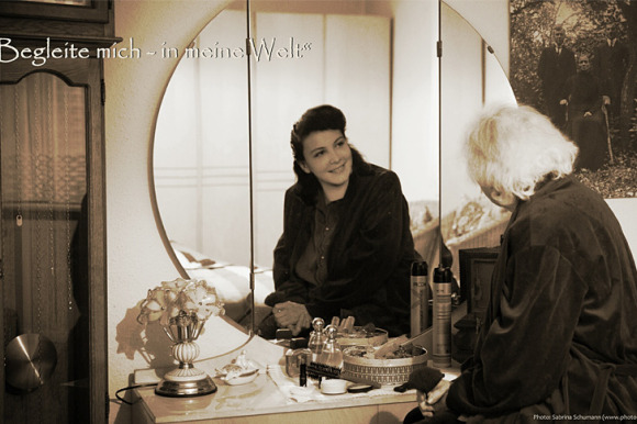 Eine ältere Frau sieht sich im Spiegelbild als junge Frau
