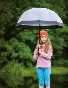 Ein Mädchen hält einen Regenschirm über sich.