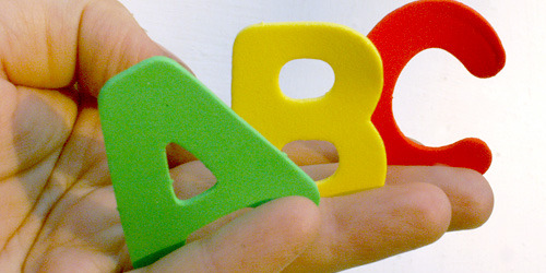 Die Buchstaben ABC aus buntem Filz auf einer Hand