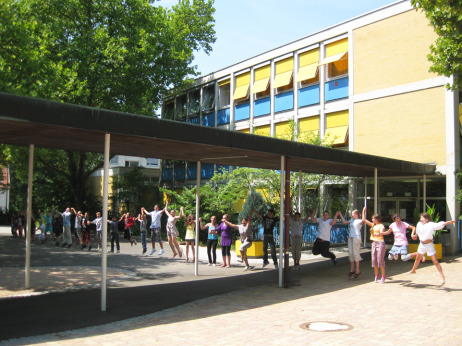 Schüler fassen sich an der Hand und bilden eine lange Kette vor ihrer Schule