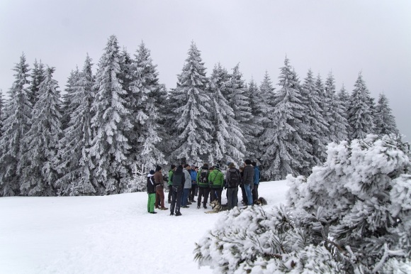 Eine Gruppe von Menschen steht in einer verschneiten Landschaft zusammen.