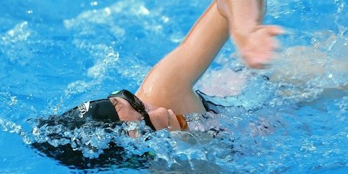 junge Schwimmerin mit Schwimmmütze und -brille