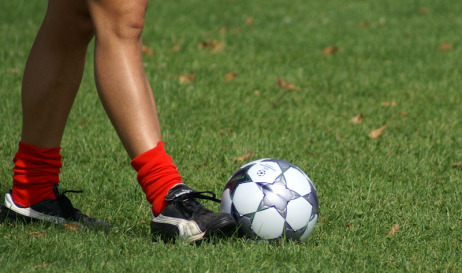 Beine eines Fußballspielers mit Ball