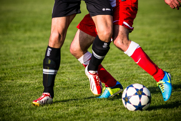 Fußballer beim Spiel - zu sehen: Beine und den Ball
