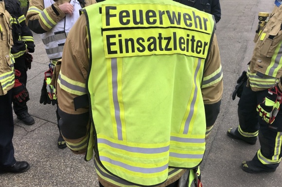 Rückseite einer gelben Warnweste mit der Aufschrit "Feuerwehr Einsatzleitung"