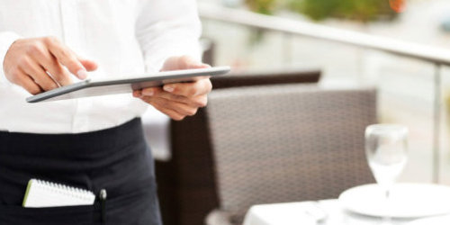 Kellner mit digitalem Tablet zur Aufnahme einer Bestellung