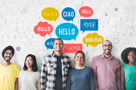 Sechs Personen mit unterschiedlicher Nationalität stehen in einer Reihe an einer Wand. Über ihnen mehrere Sprechblasen in denen das Wort "Hallo" in verschiedenen Sprachen steht.