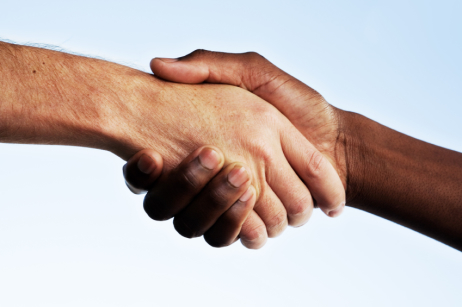 Handschlag einer weißen und einer Afroamerikanischen Hand