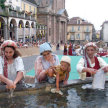 Frauen in historischer Kleidung waschen im Brunnen auf dem Kirchplatz in Moncalieri ihre Wäsche