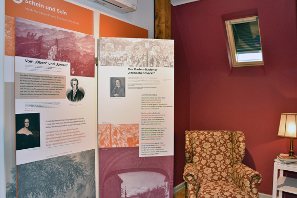 Ausstellungsbereich mit Plakaten und Sessel