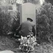 Vor dem Grabstein Otto Flakes. Ein Friedhofsbediensteter arrangiert Blumen