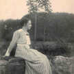 Erna Flake sitzt im seitlichen Profil auf einer Steinmauer