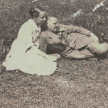 In einer Wiese lehnt Otto Flake halb liegend im Arm der sitzenden Erna