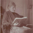 Die Mutter Otto Flakes sitzt in einem Sessel und liest in einem Buch